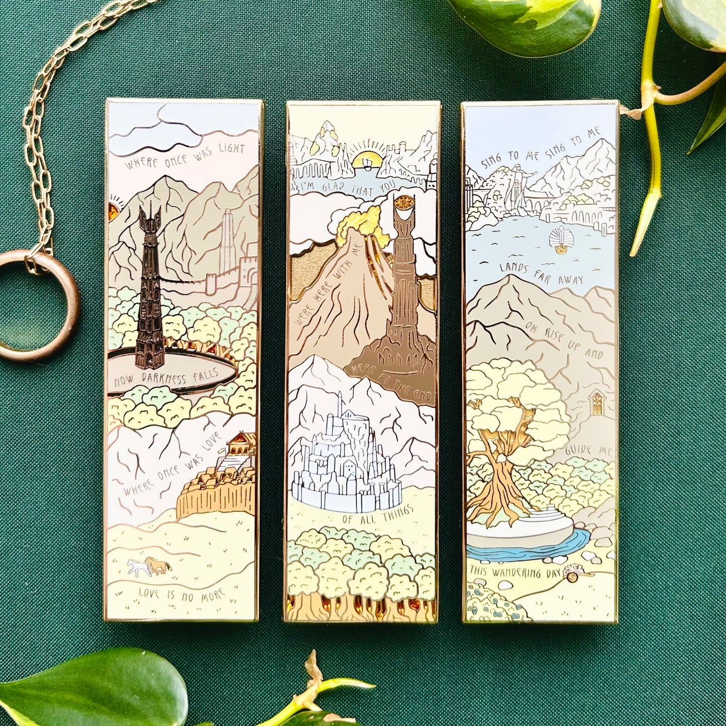 Three vertical enamel pins with scenes from the lord of the rings. The first is two towers themed, the second return of the king, and the third rings of power.