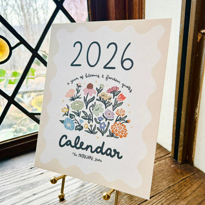 Calendar for 2026 with floral design on a wooden surface by a window