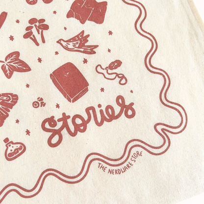 tote bag with designs in maroon that say never too old for stories with fantastical illustrations of a book, locket, moth, leaf, and more