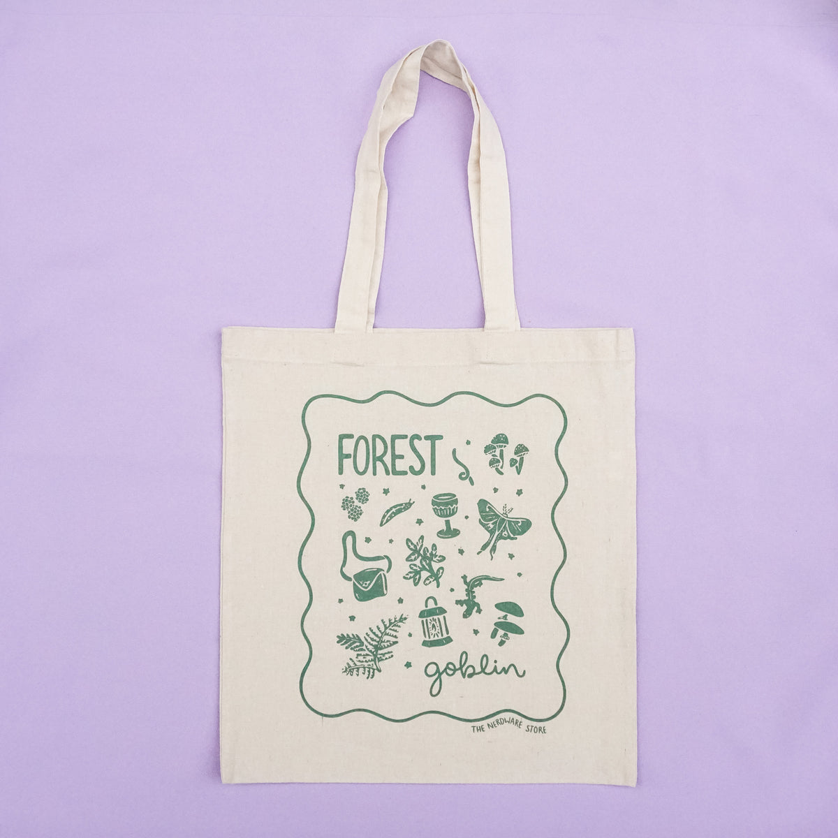 tote bag with designs in dark green that say forest goblin with fantastical illustrations of a slug, a goblet, a satchel, foliage, a lantern, mushrooms, and a luna moth