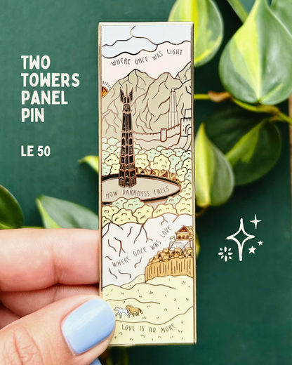Two Towers Panel Pin - LE 50 - Close up of a hand holding a vertical enamel pin with scenes from the The Two Towers and the words "where once was light now darkness falls where once was love love is no more"