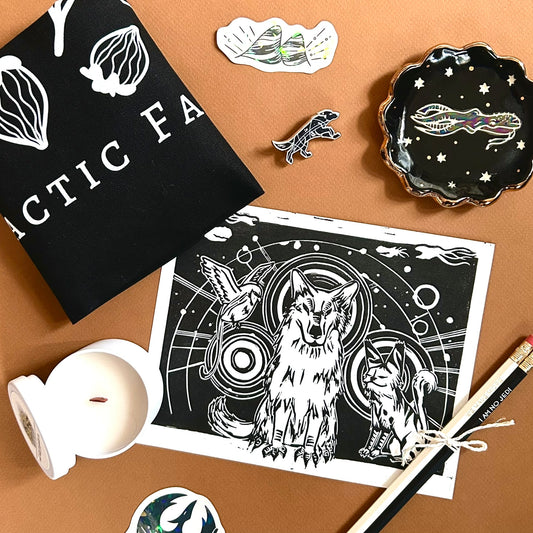 A collection of black and white star wars rebels inspired goodies, including a ceramic dish, enamel pin, ttoe bag, linocut print, pencils, and a candle.